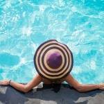 Woman in hat, leaning on pool wall