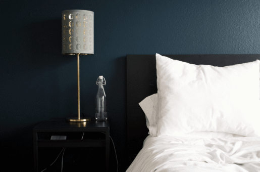 Longest-Night-blog-postpng Bed with pillows, dark headboard, and lamp, getting help with newborn sleep in Towson, Baltimore, Hunt Valley, Owings Mills, Lutherville