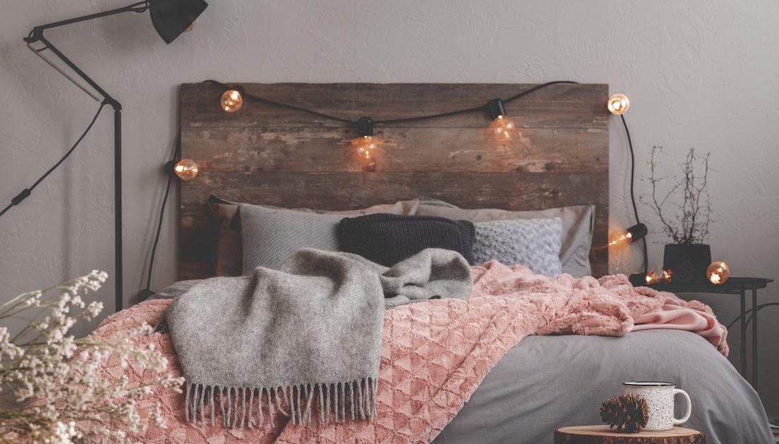 Grey and pastel pink blanket on grey bedding of fashionable bedroom cozy for long winter nights newborn overnight care