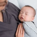 a baby is held by their professional postpartum doula