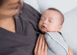 a baby is held by their professional postpartum doula