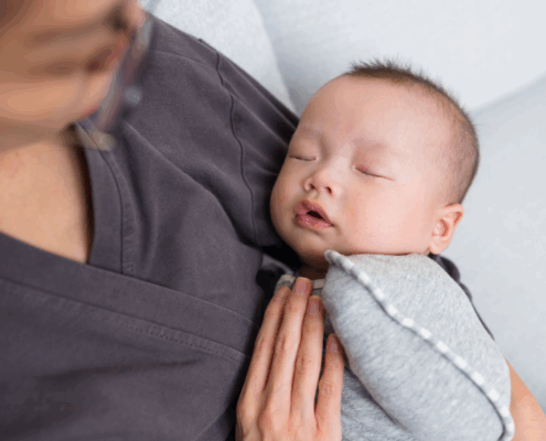 a baby is held by their professional postpartum doula