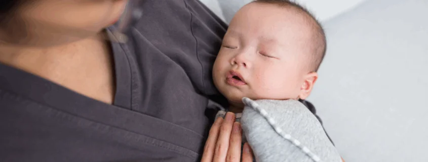 a baby is held by their professional postpartum doula