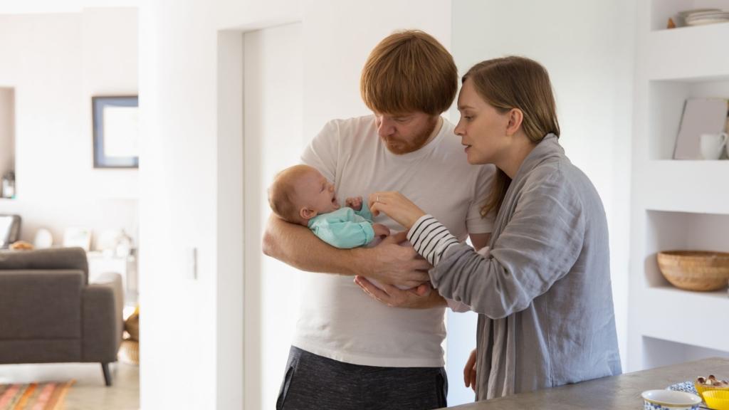 A couple tries to soothe a baby together.
