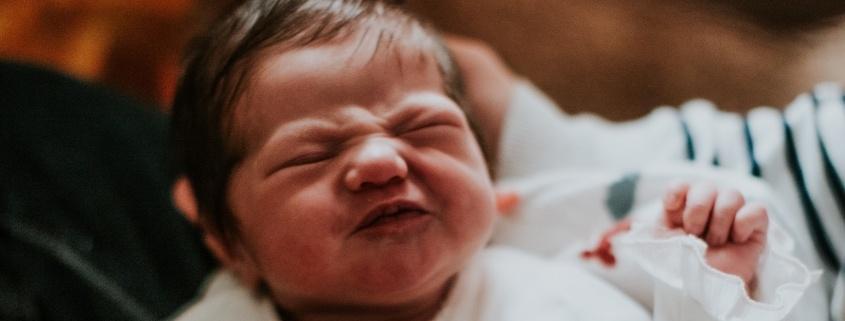 newborn baby squinting as if about to cry