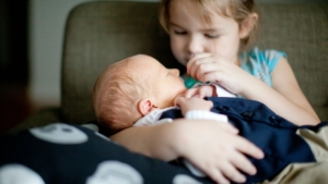 New sister holds their baby sibling