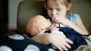 New sister holds their baby sibling