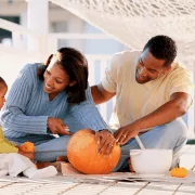 Fall fun, pumpkin carving family on Baltimore porch