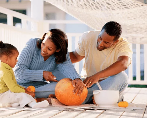 Fall fun, pumpkin carving family on Baltimore porch