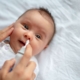 Sick baby getting saline nose drops. RSV, flu, covid Baltimore babies and families