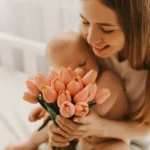 A new mother smiles at a gift she recieved for mother's day