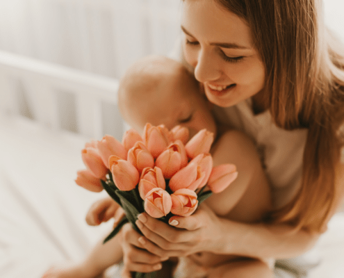 A new mother smiles at a gift she recieved for mother's day