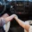 Two people hold hands in the front of a vehicle