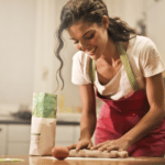 A brunette woman tends to her tasks in the kitchen.