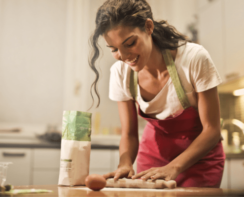 A brunette woman tends to her tasks in the kitchen.