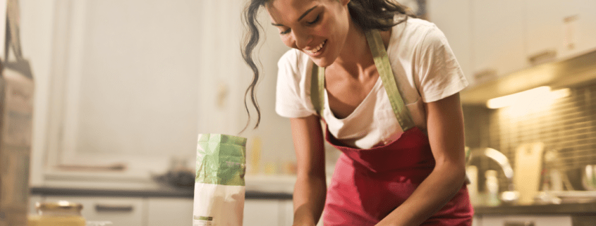 A brunette woman tends to her tasks in the kitchen.