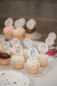 Cupcakes featuring various birth and parenting icons are displayed at Doulas of Baltimore's 10th birthday party.