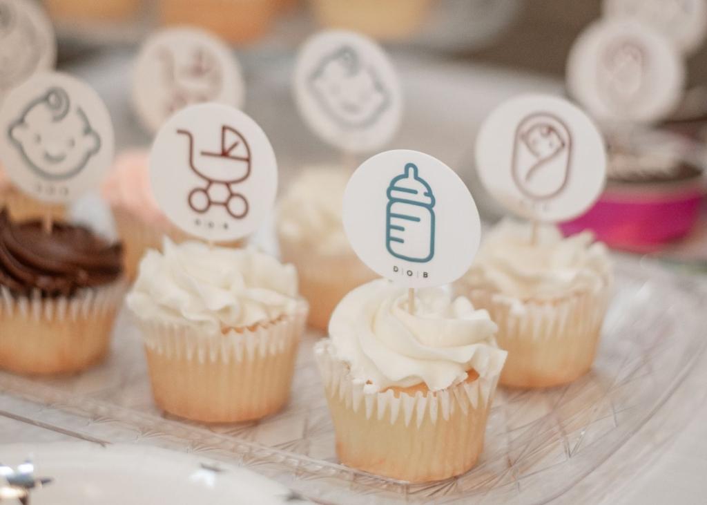 Cupcakes featuring various birth and parenting icons are displayed at Doulas of Baltimore's 10th birthday party.