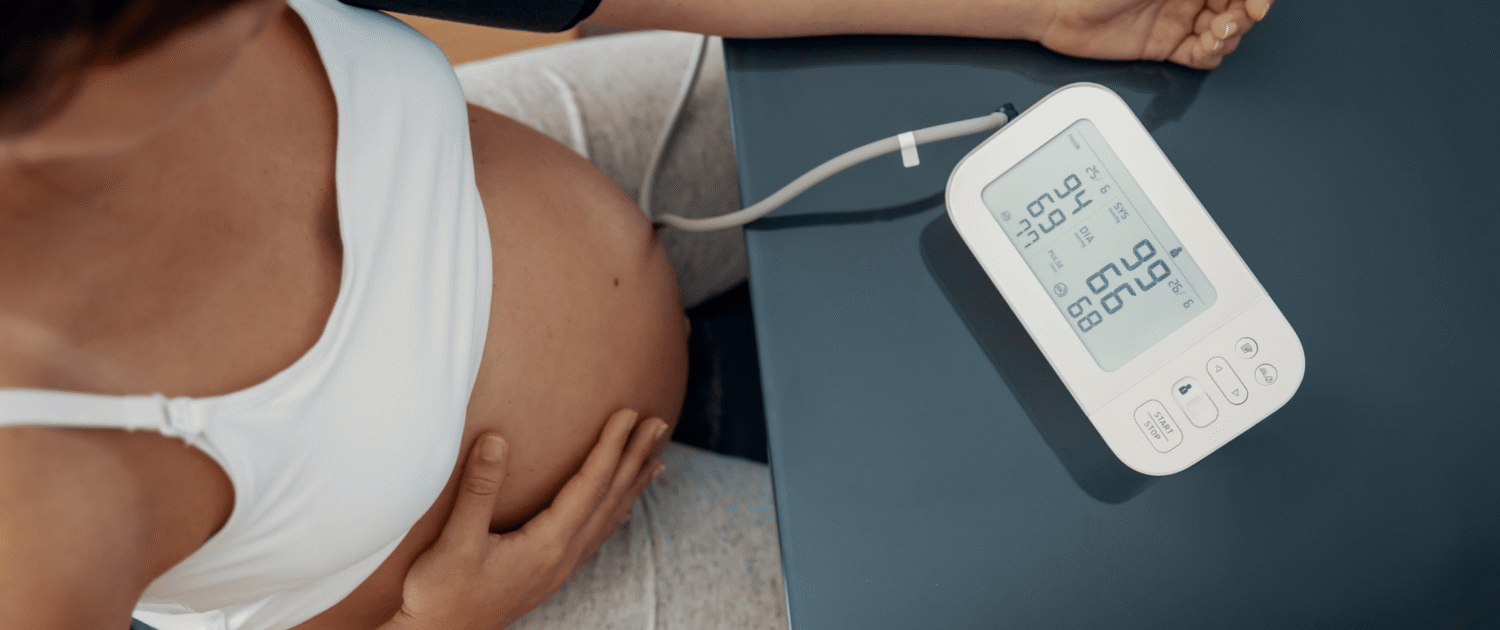Pregnant individual takes their blood pressure to monitor for hypertension, preeclampsia, or hellp in pregnancy.