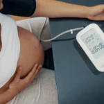 Pregnant individual takes their blood pressure to monitor for hypertension, preeclampsia, or hellp in pregnancy.