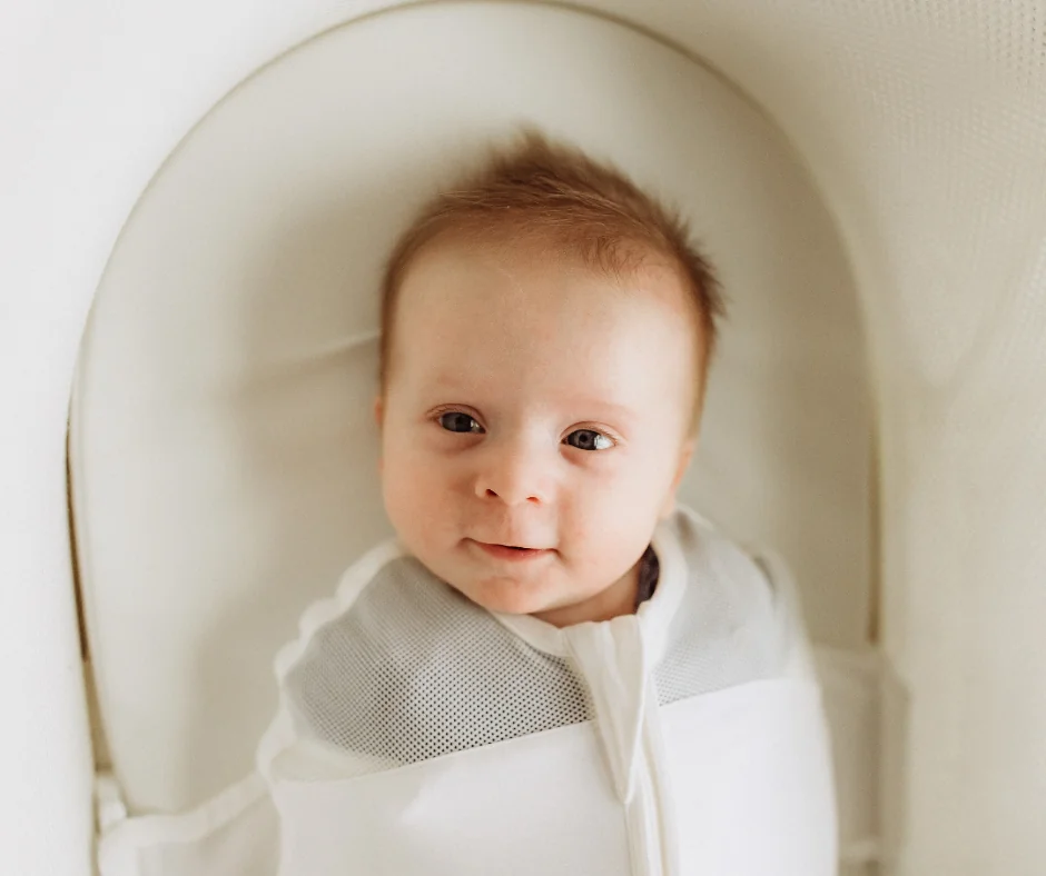 A newborn is swaddled and set into a Snoo bassinet