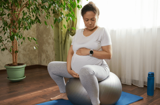A pregnant person sits on a yoga ball during early labor as a comfort and distraction technique.