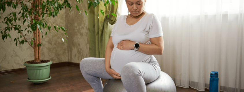 A pregnant person sits on a yoga ball during early labor as a comfort and distraction technique.