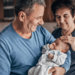 A newborn baby meets their grandparents for the first time.