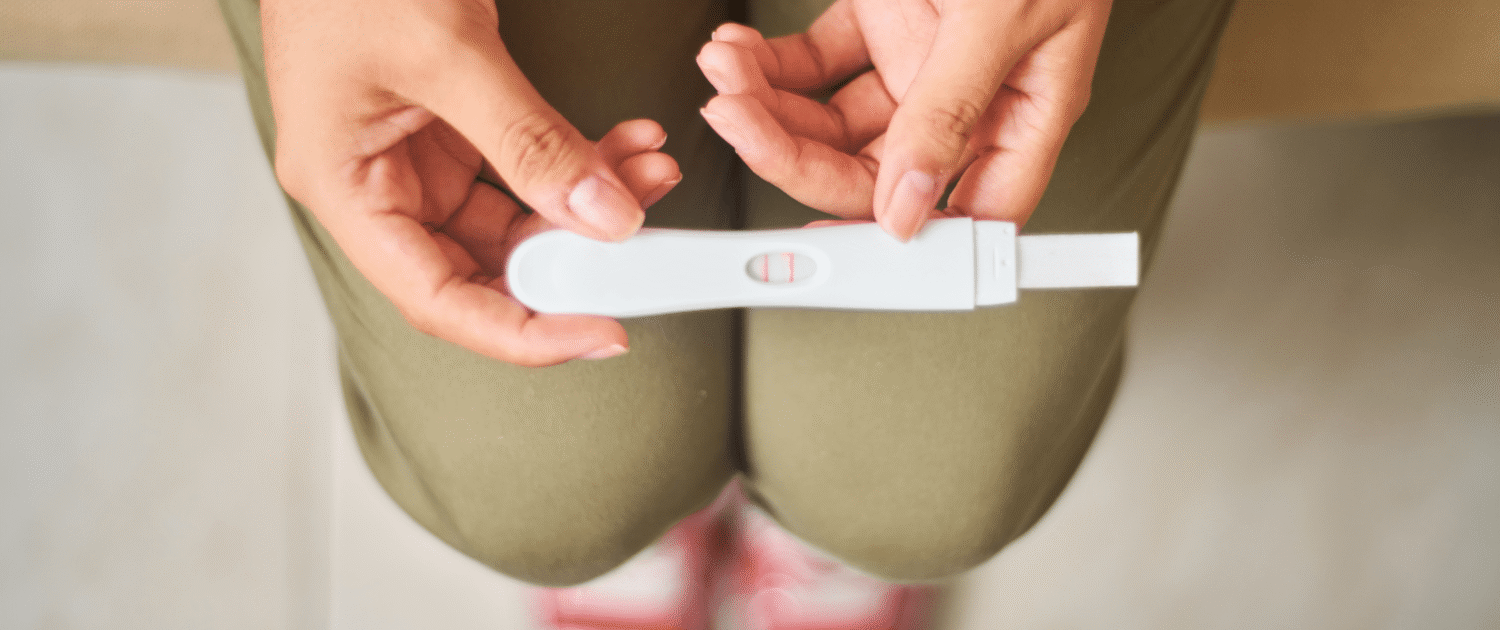 Hands hold a pregnancy test.
