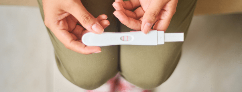 Hands hold a pregnancy test.