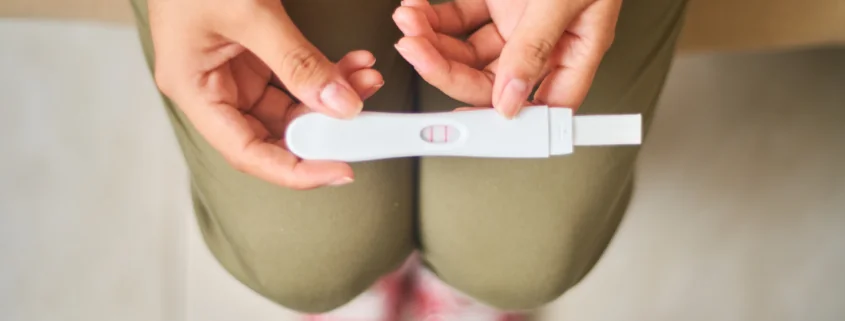 Hands hold a pregnancy test.