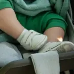 A baby in a stroller visits Baltimore's parks with their parent.