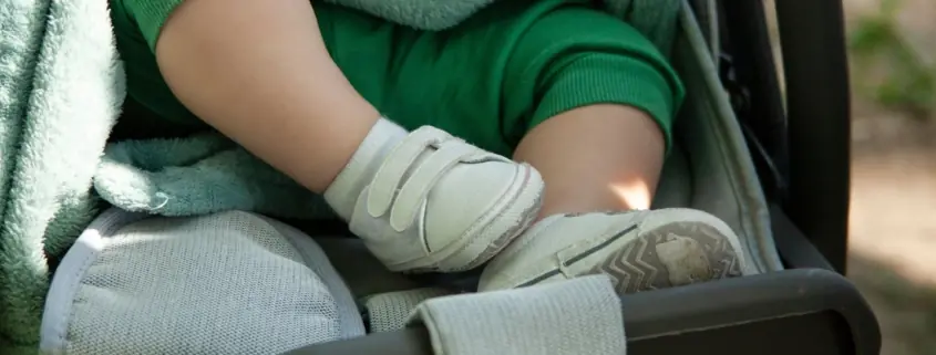 A baby in a stroller visits Baltimore's parks with their parent.
