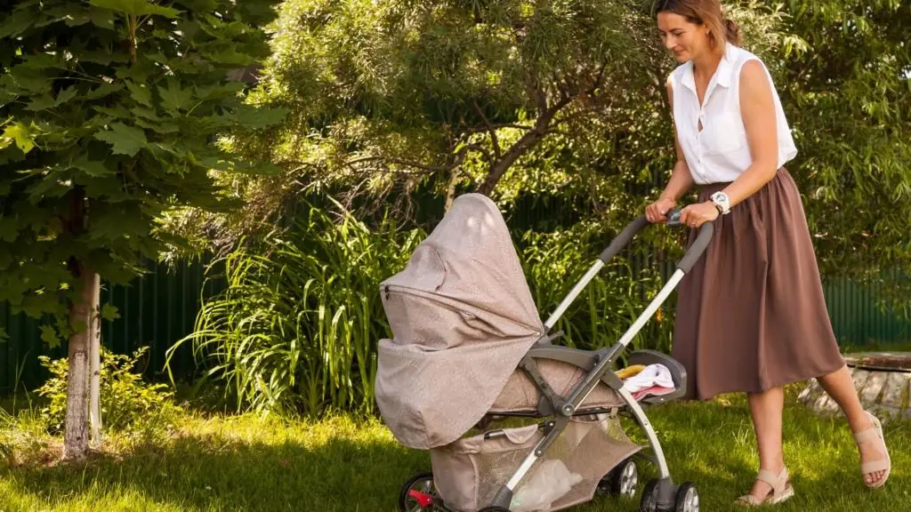 New mother in Baltimore strolls parks during the springtime with her newborn baby during postpartum.
