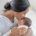 A mother kisses her newborn with moderate head molding.