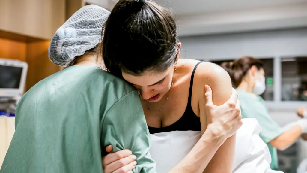 A support person offers comfort to a birthing person in labor.