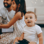 A new baby in Baltimore Maryland smiles as their family opens gifts of experiences from a gift guide.